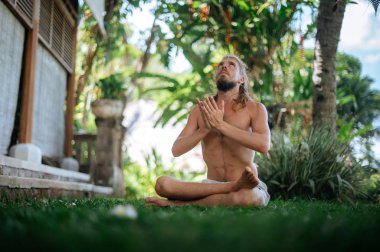 Erkek, dışarıda yoga ve meditasyon pratiği yapıyor.