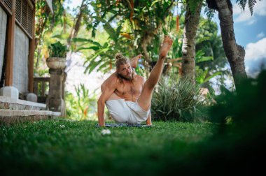 Erkek, dışarıda yoga ve meditasyon pratiği yapıyor.