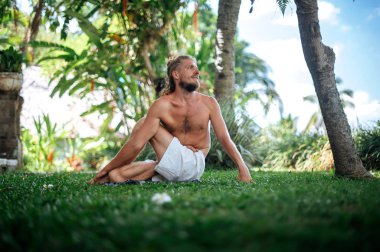 Erkek, dışarıda yoga ve meditasyon pratiği yapıyor.