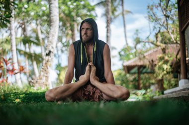 Erkek, dışarıda yoga ve meditasyon pratiği yapıyor.