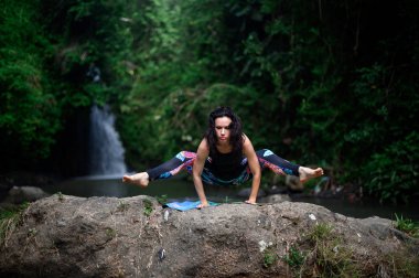 Yoga ve meditasyon doğada var. Nehir kenarında pratik yapan kadın