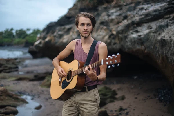 Romantic young man with a guitar on the beach — Stock Photo, Image