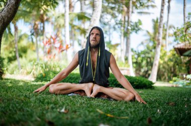 Erkek, dışarıda yoga ve meditasyon pratiği yapıyor.