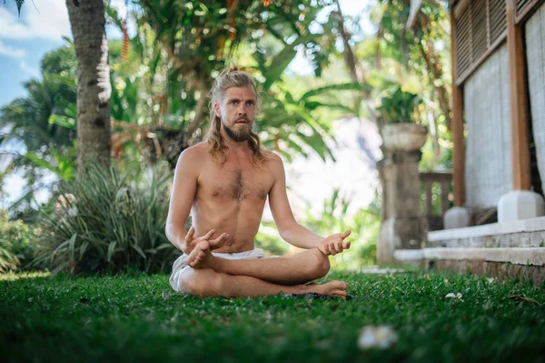 Erkek, dışarıda yoga ve meditasyon pratiği yapıyor.