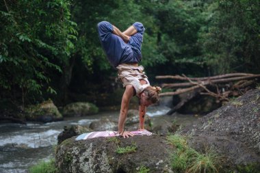 Yoga uygulaması ve doğada meditasyon. Nehir yakınlarında pratik yapan adam
