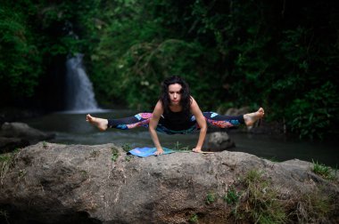 Yoga ve meditasyon doğada var. Nehir kenarında pratik yapan kadın