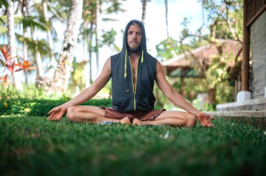 Erkek, dışarıda yoga ve meditasyon pratiği yapıyor.