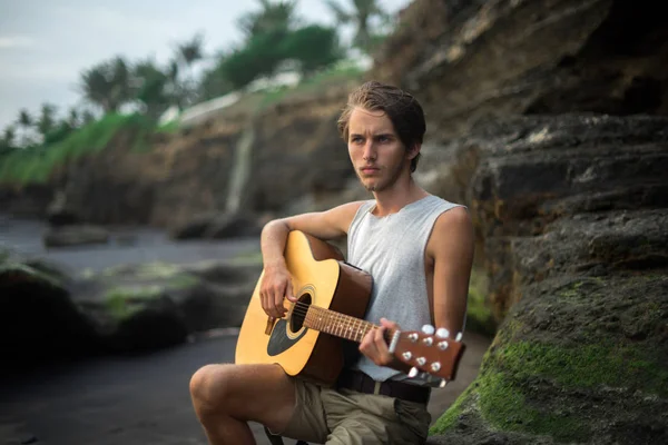 Романтичный молодой человек с гитарой на пляже — стоковое фото