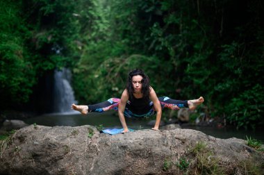 Yoga ve meditasyon doğada var. Nehir kenarında pratik yapan kadın