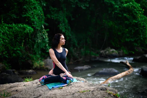 Yoga practice and meditation in nature. Woman practicing near river — 스톡 사진