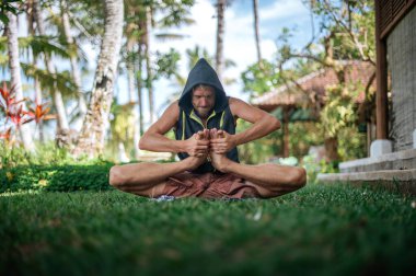 Erkek, dışarıda yoga ve meditasyon pratiği yapıyor.