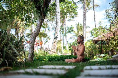 Erkek, dışarıda yoga ve meditasyon pratiği yapıyor.
