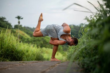 Erkek, dışarıda yoga ve meditasyon pratiği yapıyor.