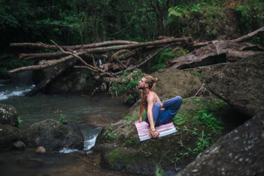 Yoga uygulaması ve doğada meditasyon. Nehir yakınlarında pratik yapan adam