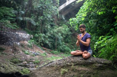 Erkek, dışarıda yoga ve meditasyon pratiği yapıyor.