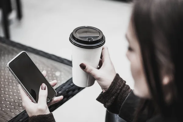 コーヒーを飲むのスマート フォンを持つ女性. — ストック写真
