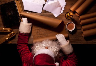 Noel Baba odasında masada oturan ve gönüllülük Noel mektup ya da dilek listesi