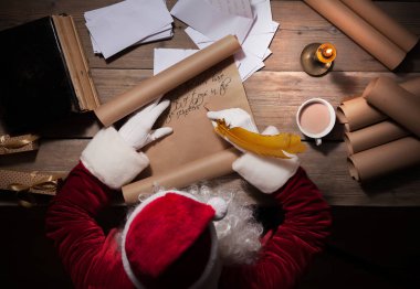 Noel Baba odasında masada oturan ve Noel mektup ya da dilek listesi yazma