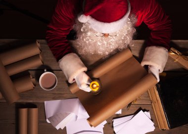 Noel Baba odasında masada oturan ve gönüllülük Noel mektup ya da dilek listesi