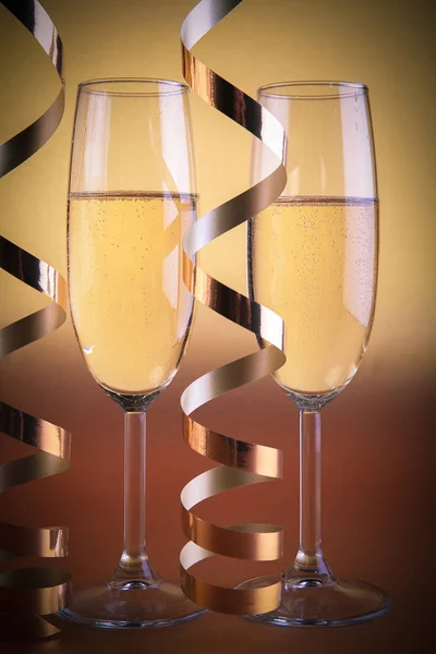 Twee champagneglazen, op gouden achtergrond — Stockfoto