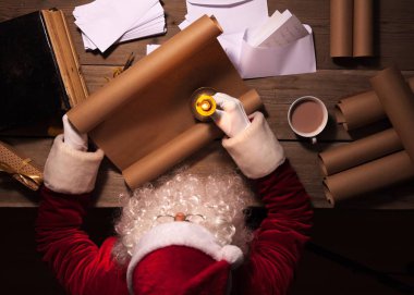 Noel Baba odasında masada oturan ve gönüllülük Noel mektup ya da dilek listesi