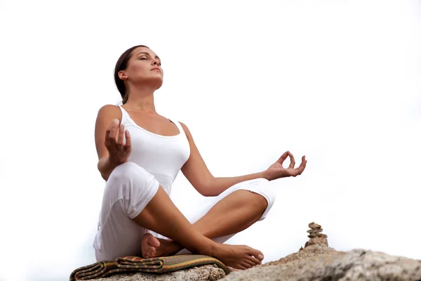Женщина медитирует в позе йоги на пляже — стоковое фото