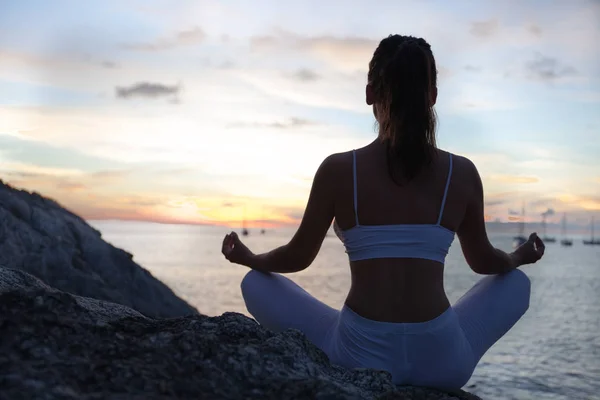 Женщина медитирует в позе йоги на пляже — стоковое фото