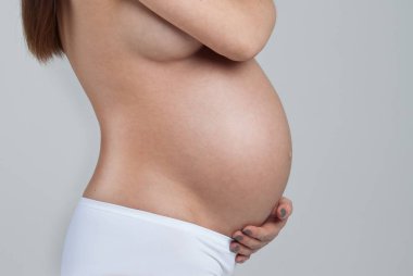 beyaz zemin üzerine izole hamile bir kadının karnı