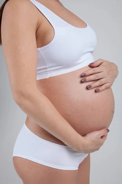 Barriga de uma mulher grávida isolada no fundo branco — Fotografia de Stock