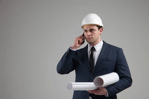 Retrato de um homem de negócios em capacete branco no fundo cinza — Fotografia de Stock