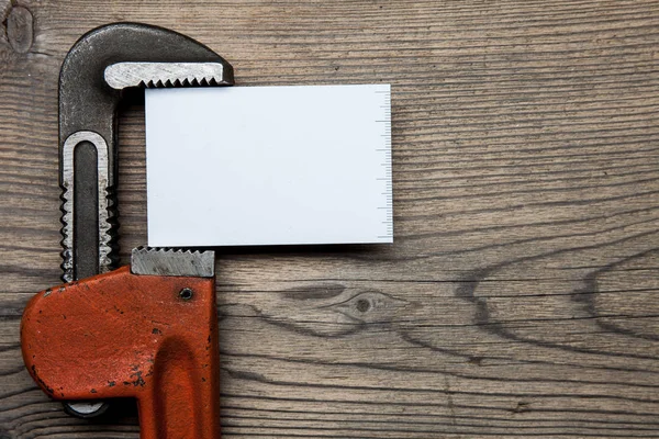 Conjunto de accesorios de tuberías de plomería y tarjeta de visita en el fondo de madera — Foto de Stock