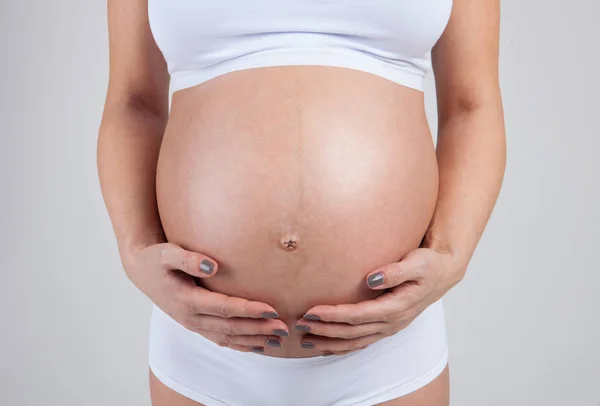 Barriga de uma mulher grávida isolada no fundo branco — Fotografia de Stock