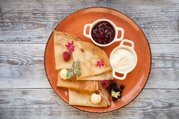 Panquecas com nata e engarrafamento e bagas frescas em uma chapa — Fotografia de Stock