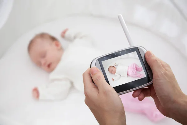 Mão segurando vídeo monitor de bebê para a segurança do bebê — Fotografia de Stock