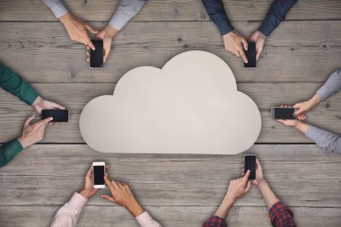 İş ekibi akıllı telefonlar üzerinde çalışıyor. Kablosuz kavramı paylaşımı bulut