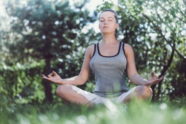 Genç Kız parkta yoga yaparken