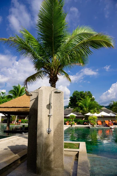 Outdoor shower next to the pool and palm trees — Stock Photo, Image