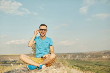 Gülümseyen ve güneşli yaz günü zevk genç adam