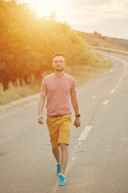 Gülümseyen ve güneşli yaz günü zevk genç adam