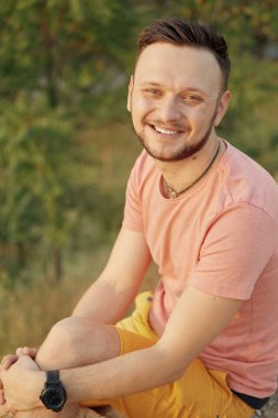 Gülümseyen ve güneşli yaz günü zevk genç adam