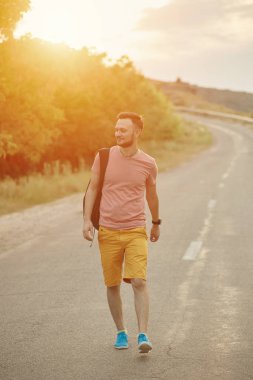 Gülümseyen ve güneşli yaz günü zevk genç adam