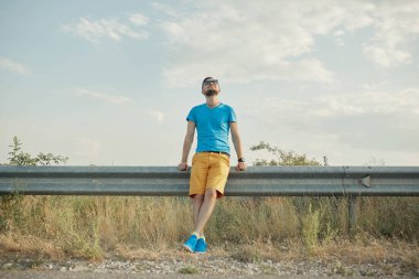 Gülümseyen ve güneşli yaz günü zevk genç adam