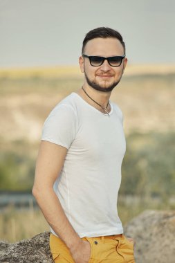 Gülümseyen ve güneşli yaz günü zevk genç adam