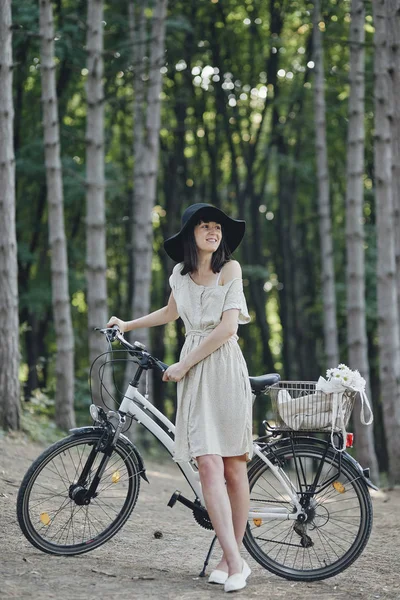 Junge Frau vor Naturkulisse mit Fahrrad — Stockfoto