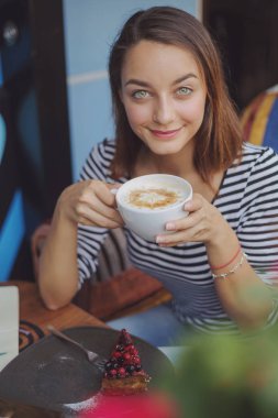 kapalı kentsel cafede oturan genç kadın