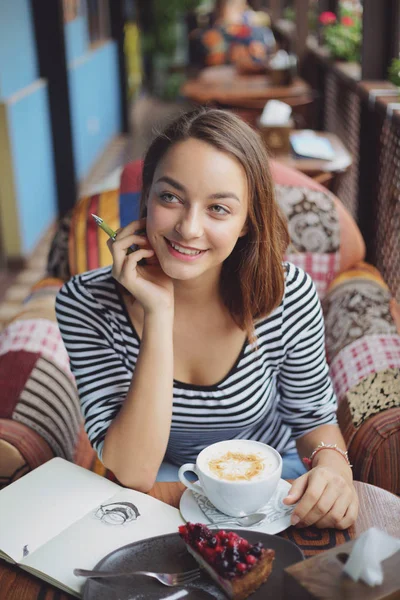 Junge Frau sitzt drinnen in urbanem Café — Stockfoto