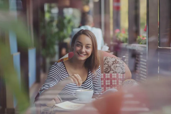 Jonge vrouw zitten binnen in stedelijke café — Stockfoto