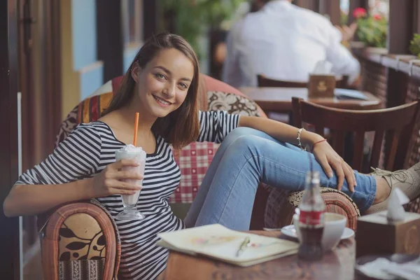 Mujer joven sentada en el interior de un café urbano —  Fotos de Stock