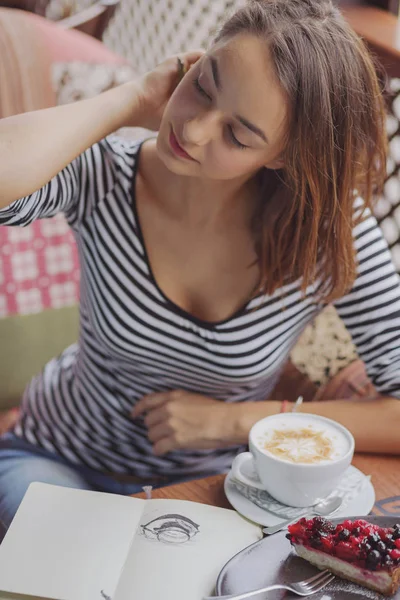 Fiatal nő ül a fedett városi kávézó — Stock Fotó