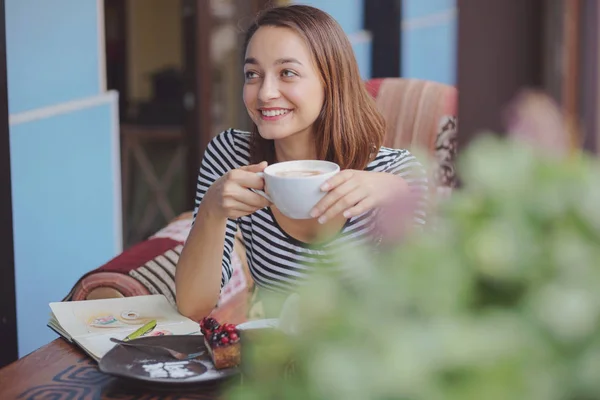 Fiatal nő ül a fedett városi kávézó — Stock Fotó